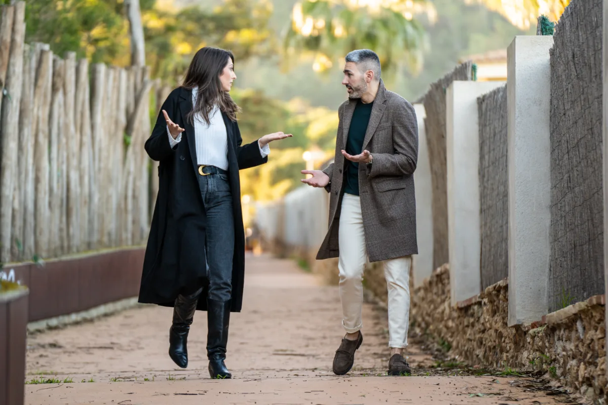 Two people engaged in a conversation while walking on a path.
