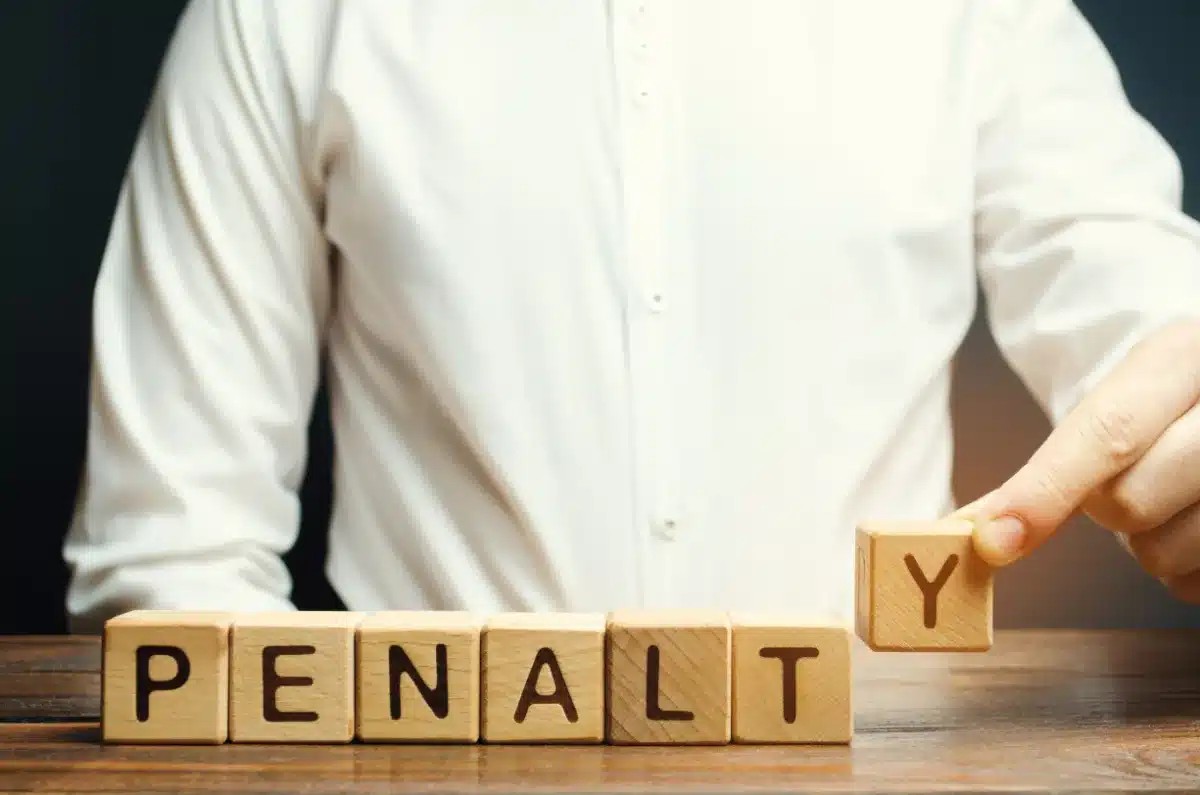 A lawyer holding a wooden block with the word penalty on it.