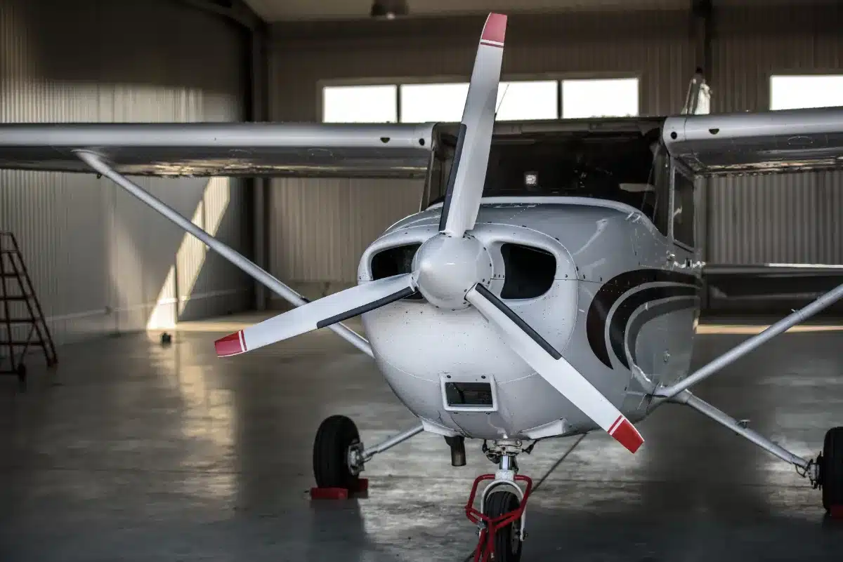 A small propeller airplane sits in a hangar, unaffected by any legal trouble or wrongdoing.