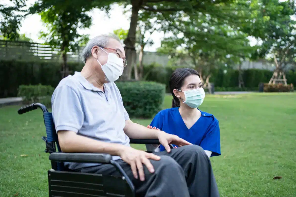 A man in a wheelchair and a woman wearing a face mask seek legal advice from a lawyer.