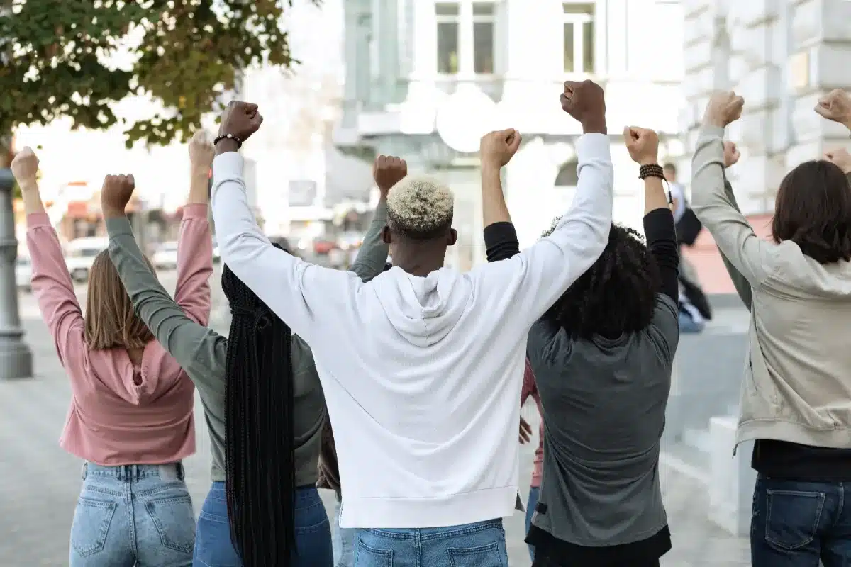 A group of people showing their solidarity by raising their fists in the air.
