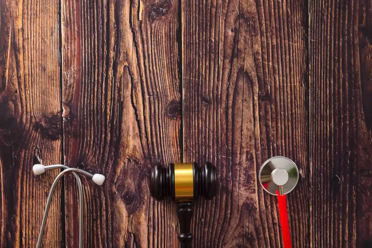 A red stethoscope on a wooden background.