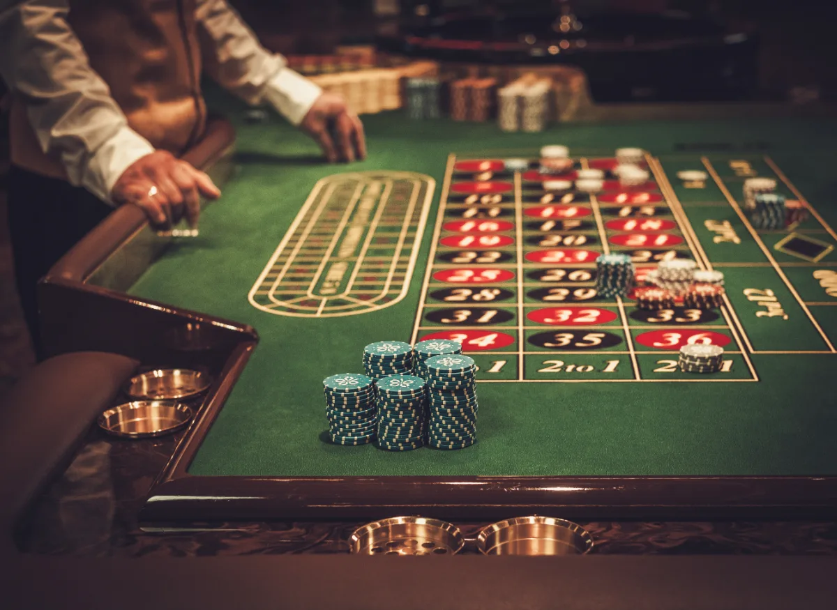 A man is playing roule on a casino table.