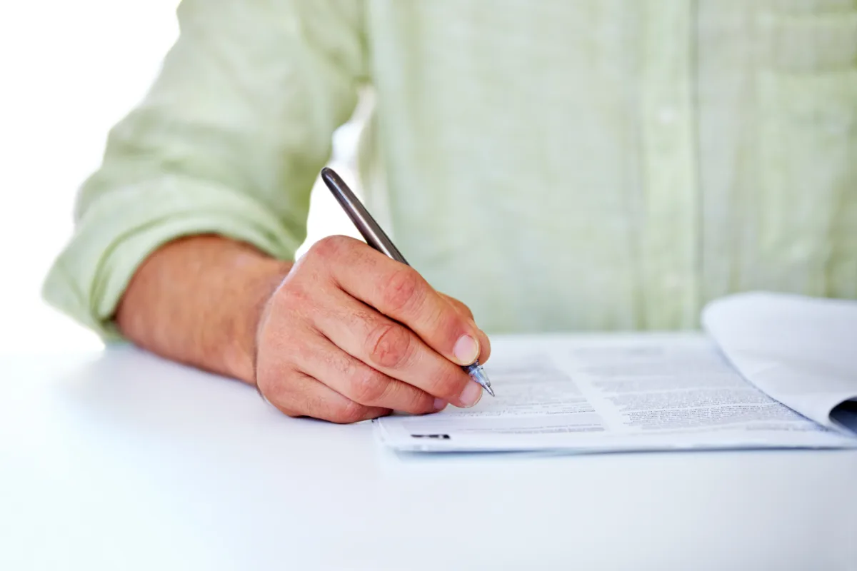 A lawyer signing a document with a pen.