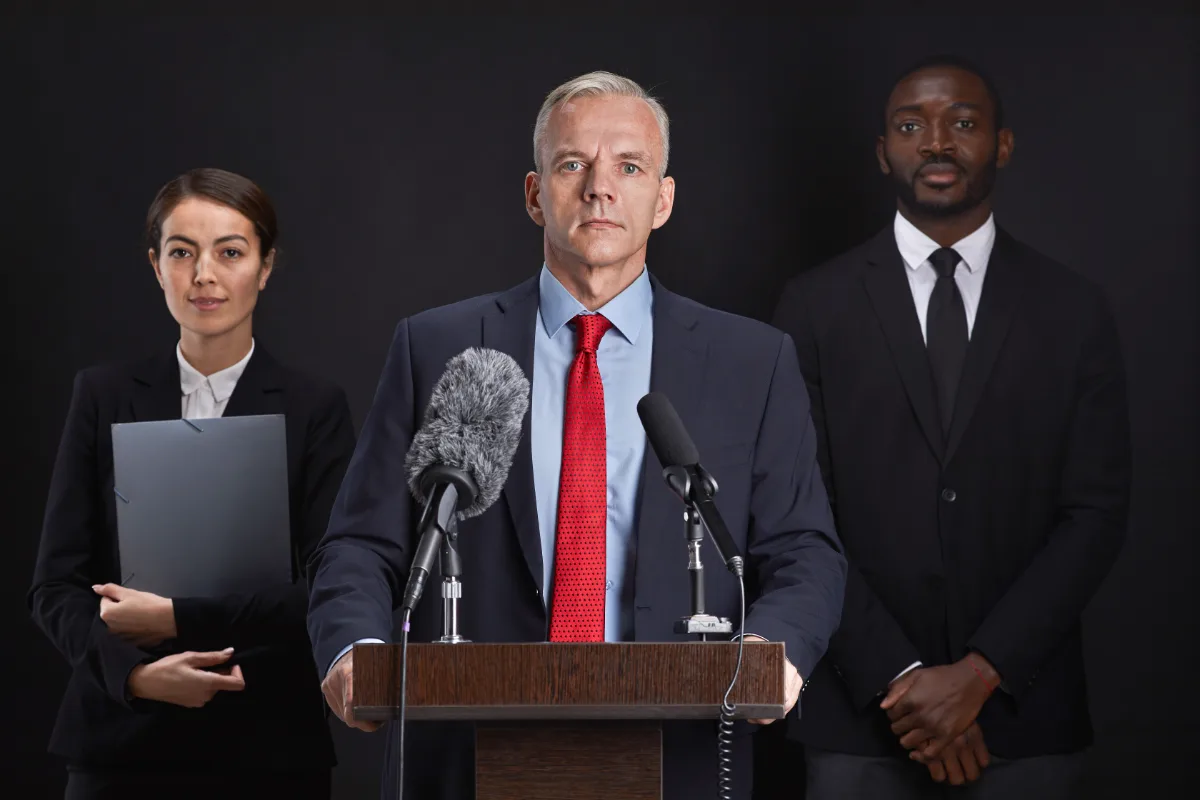 A group of business people, including a lawyer, standing behind a podium.